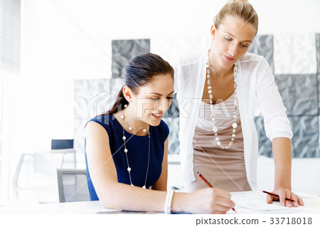 Two female colleagues in office 33718018