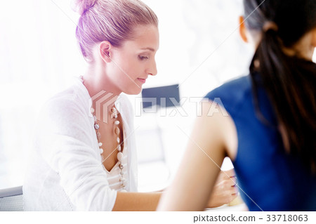 Two female colleagues in office Two female colleagues in office 33718063