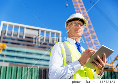 Engineer builder at construction site 33718423