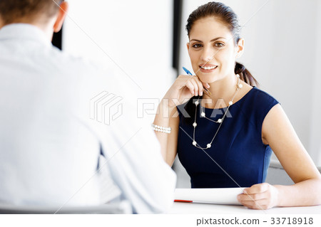 Attractive office worker sitting at desk Attractive office worker sitting at desk 33718918