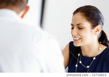 Attractive office worker sitting at desk Attractive office worker sitting at desk 33718923