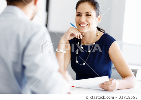 Attractive office worker sitting at desk 33719555
