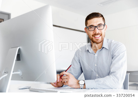 Male office worker sitting at desk 33720054