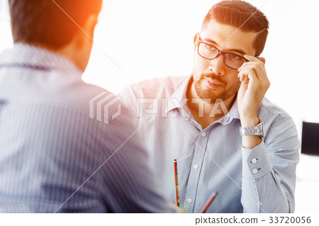Attractive office worker sitting at desk Attractive office worker sitting at desk 33720056