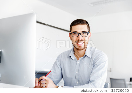 Male office worker sitting at desk Male office worker sitting at desk 33720060