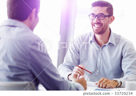 Attractive office worker sitting at desk Attractive office worker sitting at desk 33720234
