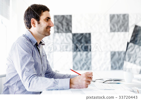 Male office worker sitting at desk Male office worker sitting at desk 33720443