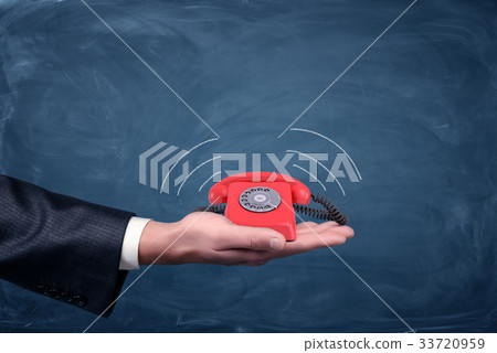 A businessman's palm hold a small red retro dial A businessman's palm hold a small red retro dial 33720959