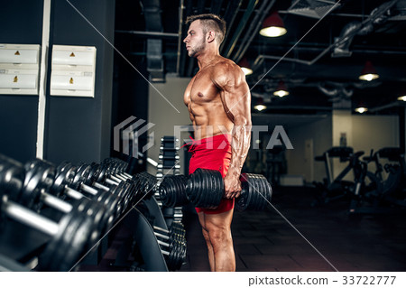 Handsome muscular man posing at a gym 33722777