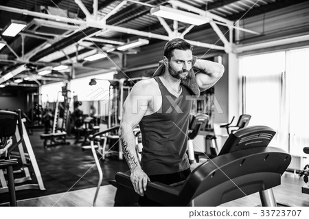 Man with a towel beside a treadmill 33723707