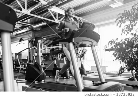 Young fitness woman doing cardio exercises at the Young fitness woman doing cardio exercises at the 33723922