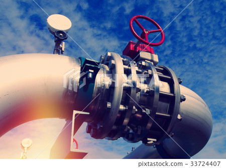 Steel pipelines and valves against blue sky 33724407