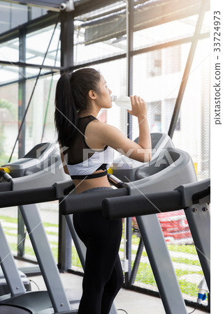 Fitness woman drinking water from bottle after run 33724973