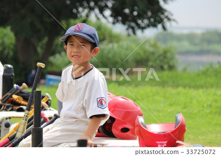 Smiling baseball boy sitting on a bench and cheering on the game Smiling baseball boy sitting on a bench and cheering on the game 33725072