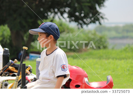 Smiling baseball boy 2 sitting on a bench and cheering on the game Smiling baseball boy 2 sitting on a bench and cheering on the game 33725073