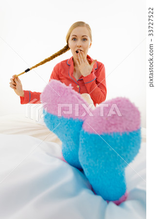 Woman in pajamas wearing furry warm socks 33727522