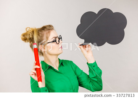 Woman holding big oversized pencil thinking Woman holding big oversized pencil thinking 33727813