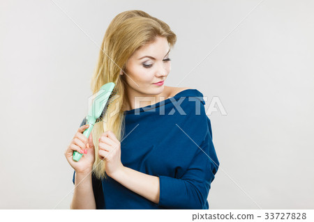 Woman brushing her long hair with brush Woman brushing her long hair with brush 33727828