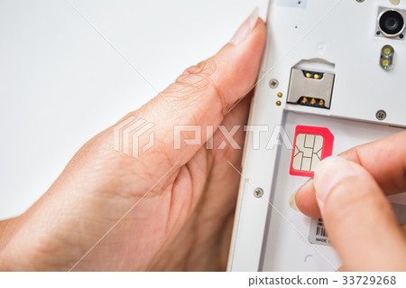 Hand holding sim card insert to the sim card tray Hand holding sim card insert to the sim card tray 33729268