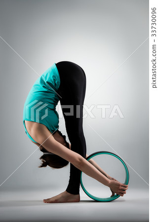 beautiful yoga woman standing in grey background 33730096