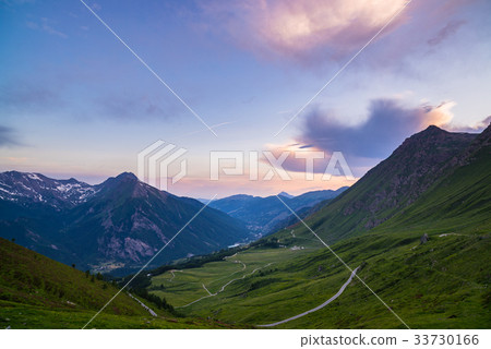 Dirt mountain road leading to high mountain pass 33730166