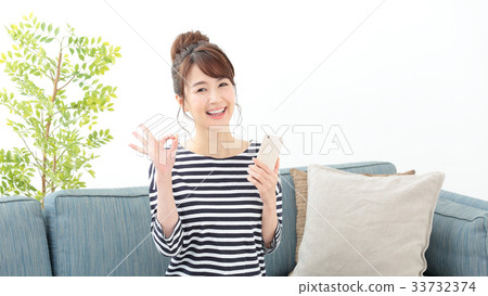 A woman relaxing on a sofa · Smartphone 33732374