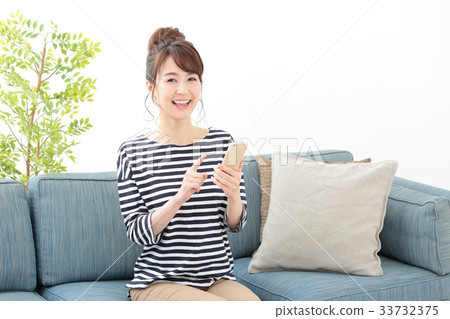 A woman relaxing on a sofa · Smartphone 33732375