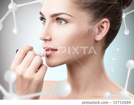 Young woman putting lipbalm among 33732689