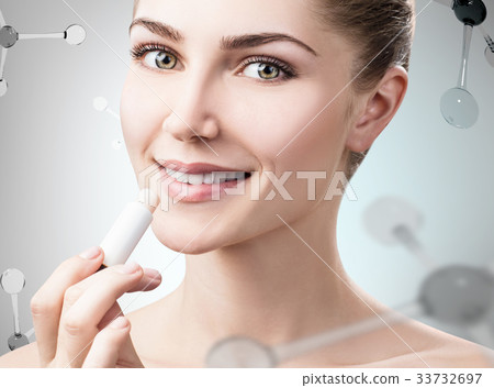 Young woman putting lipbalm among 33732697
