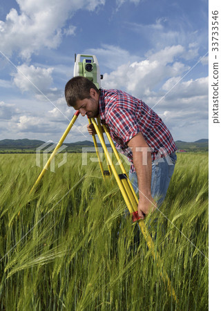 Land surveyor in agriculture field of wheat 33733546