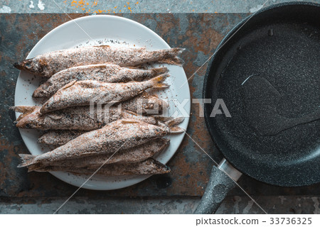 Fish on a plate, frying pan on a gray beige 33736325