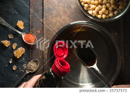 Soy sauce is poured into a spoon over a Soy sauce is poured into a spoon over a 33737573