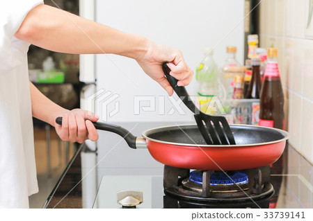Woman holding a pan in the hand cooking omelette. Woman holding a pan in the hand cooking omelette. 33739141