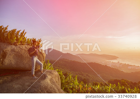 Hipster young girl with backpack enjoying sunset  33740928