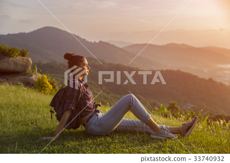 Hipster young girl with backpack enjoying sunset Hipster young girl with backpack enjoying sunset 33740932
