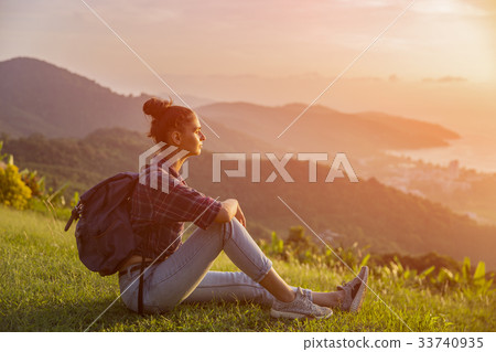 Hipster young girl with backpack enjoying sunset  33740935