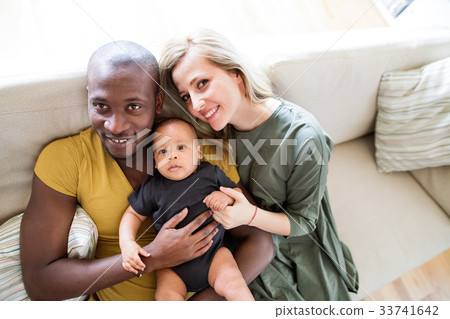 Young interracial family with little baby son at 33741642