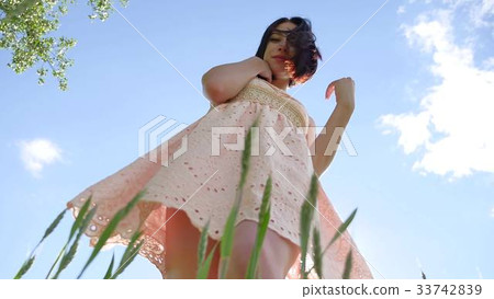 Girl sexy in a dress in a field of green grass 33742839