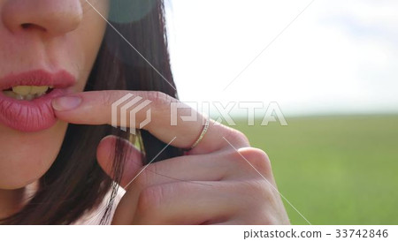 The girl touches her lips and her hair flutters in The girl touches her lips and her hair flutters in 33742846