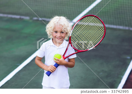 Child playing tennis on outdoor court 33742995