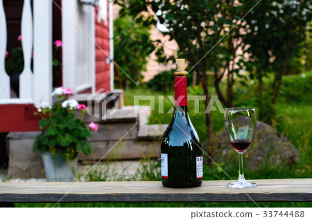 Bottle and a wineglass of wine. 33744488