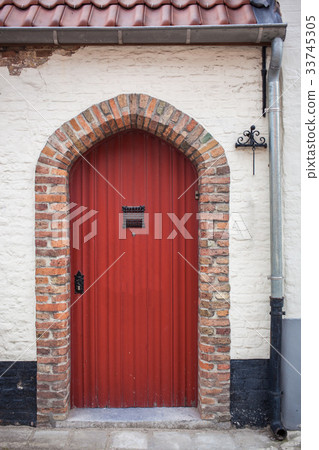 Red door in stone building 33745305