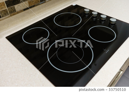 Modern black induction stove in kitchen interior 33750510