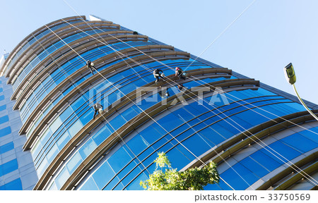 Industrial alpinists cleaning skyscraper 33750569