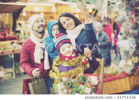 Parents with children buying holidays decorations 33751316