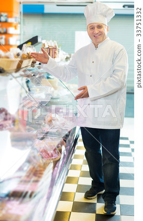 Salesman offering different sausages 33751332