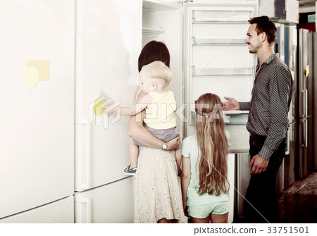 family of four shopping new refrigerator in home appliance store 33751501