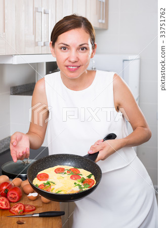 woman preparing omelet in pan woman preparing omelet in pan 33751762