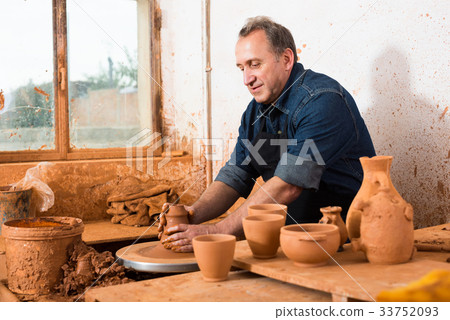 Elderly master at the pottery workshop. 33752093