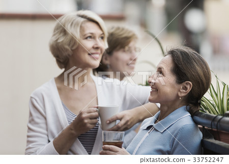 Three women drinking tea at balcony 33752247